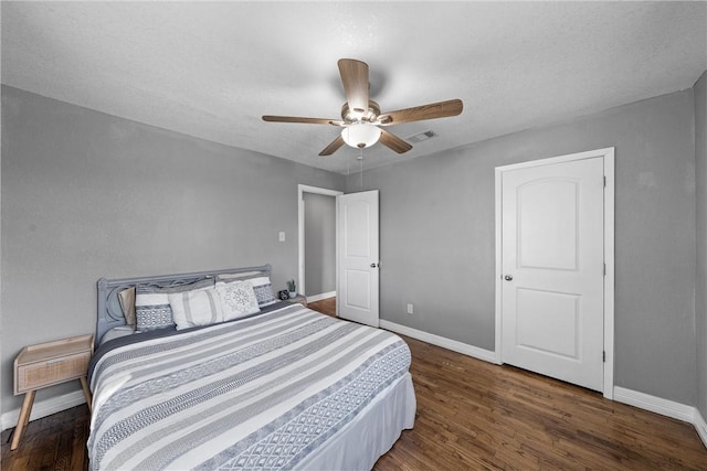 bedroom featuring ceiling fan, visible vents, baseboards, and wood finished floors