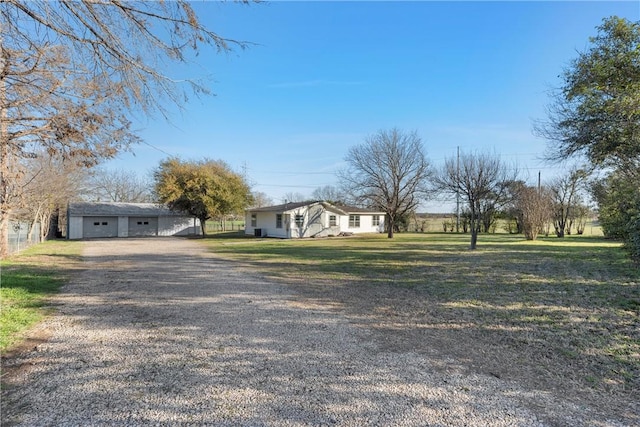 single story home with a detached garage and a front lawn