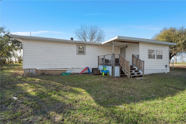 rear view of house featuring a yard