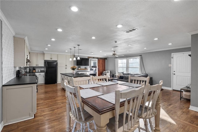 dining area with dark wood finished floors, recessed lighting, visible vents, and ornamental molding