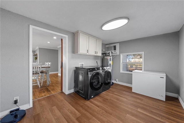 laundry area with wood finished floors, cabinet space, baseboards, and washer and clothes dryer