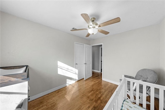 bedroom with a ceiling fan, baseboards, and wood finished floors