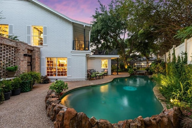 pool at dusk featuring a patio area