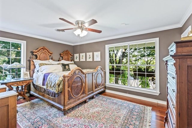 bedroom featuring multiple windows, ceiling fan, hardwood / wood-style floors, and crown molding