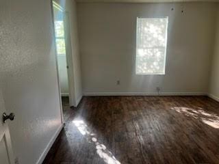 spare room with dark hardwood / wood-style flooring