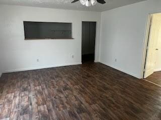 unfurnished bedroom featuring ceiling fan and dark wood-type flooring