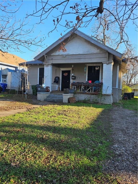 bungalow-style home with a front yard