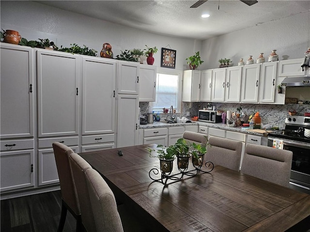 kitchen featuring white cabinets, electric range, and sink