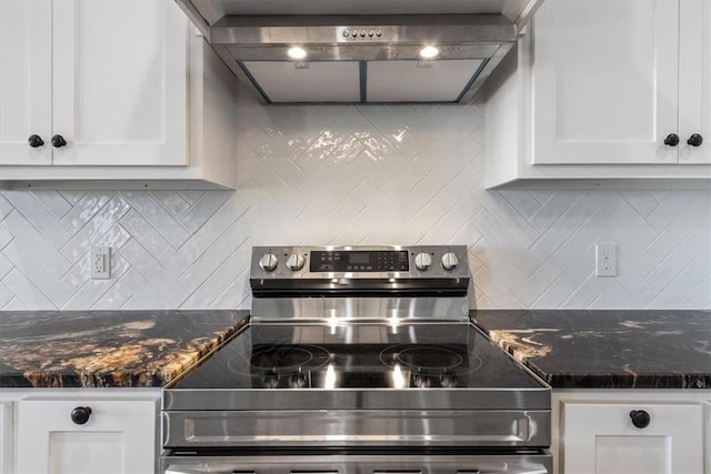 kitchen featuring white cabinets, tasteful backsplash, stainless steel range with electric cooktop, and wall chimney range hood