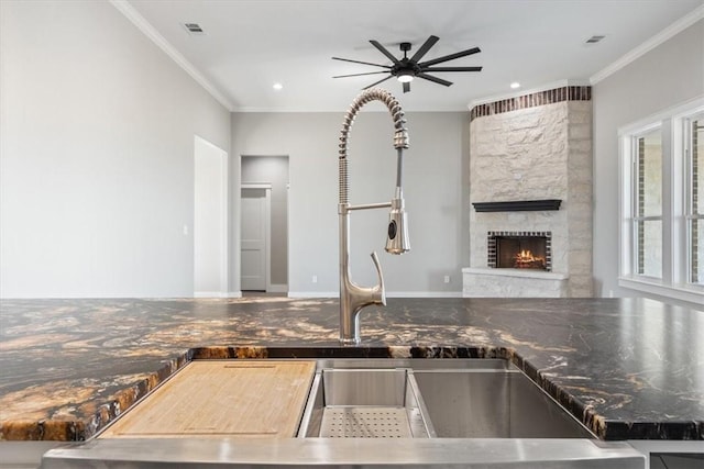 kitchen featuring crown molding, a fireplace, and ceiling fan