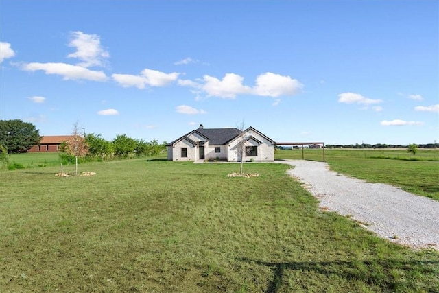 view of front of house with a rural view, a front yard, and a carport