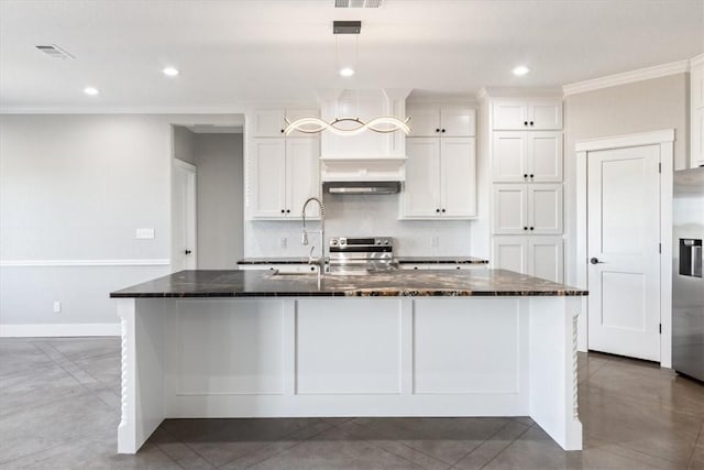 kitchen with white cabinets, an island with sink, dark stone counters, and stainless steel appliances