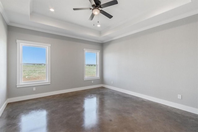 empty room featuring ceiling fan, ornamental molding, and a tray ceiling