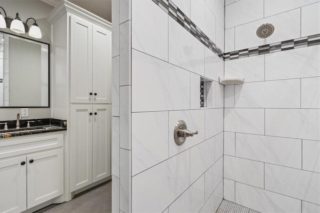 bathroom with a tile shower and vanity