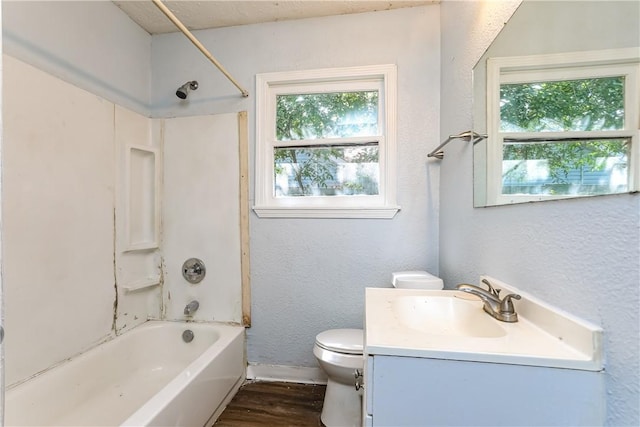 full bathroom with hardwood / wood-style flooring, vanity, toilet, and washtub / shower combination