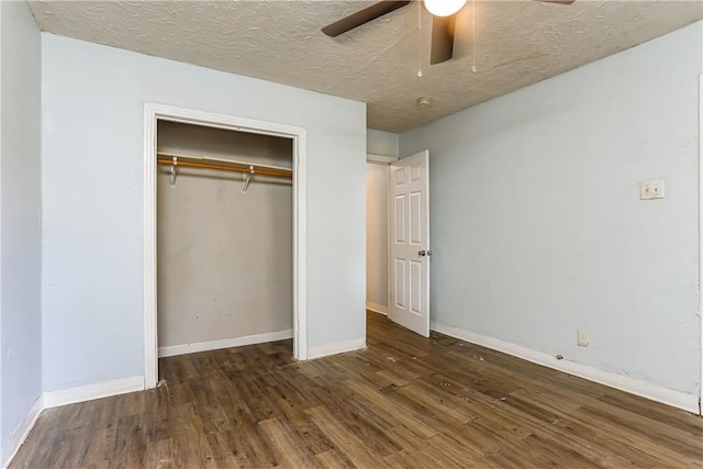 unfurnished bedroom featuring a textured ceiling, a closet, ceiling fan, and dark wood-type flooring