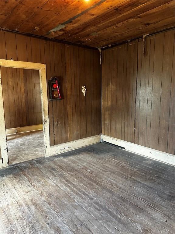 interior space featuring wooden ceiling, dark wood-type flooring, and wooden walls