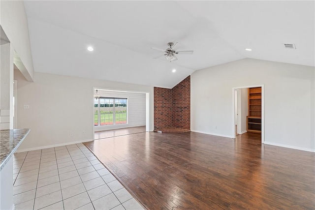 unfurnished living room with a fireplace, light hardwood / wood-style floors, ceiling fan, and lofted ceiling