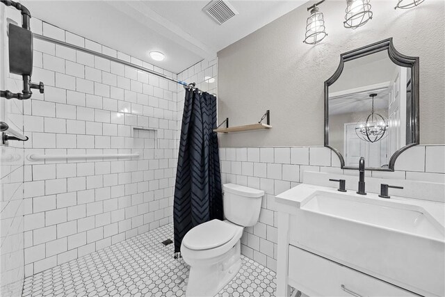 bathroom featuring tile patterned flooring, toilet, vanity, tile walls, and a shower with shower curtain