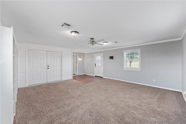 carpeted spare room featuring crown molding and ceiling fan