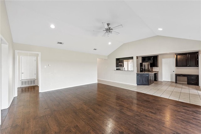 unfurnished living room featuring ceiling fan, light hardwood / wood-style flooring, and vaulted ceiling