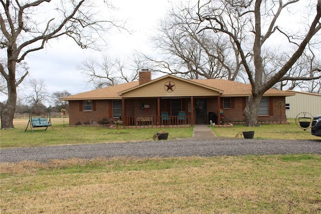 ranch-style home featuring a front yard and covered porch