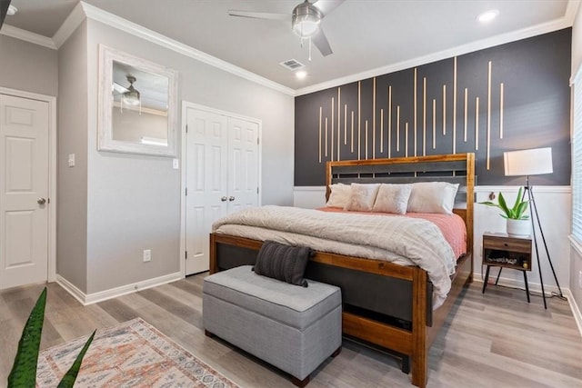 bedroom with ceiling fan, light wood-style flooring, visible vents, baseboards, and crown molding