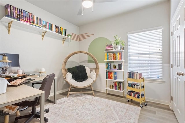 home office with light wood finished floors, baseboards, and a ceiling fan