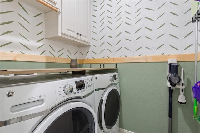 washroom with washing machine and clothes dryer and cabinet space