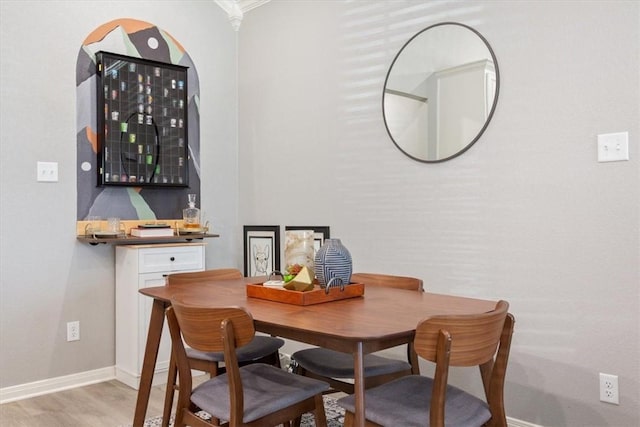 dining space with light wood finished floors and baseboards