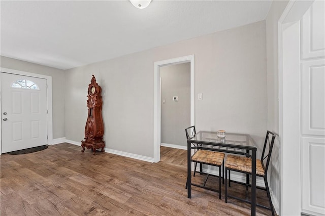 foyer featuring baseboards and wood finished floors