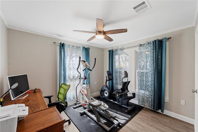 workout room with baseboards, visible vents, a ceiling fan, wood finished floors, and crown molding