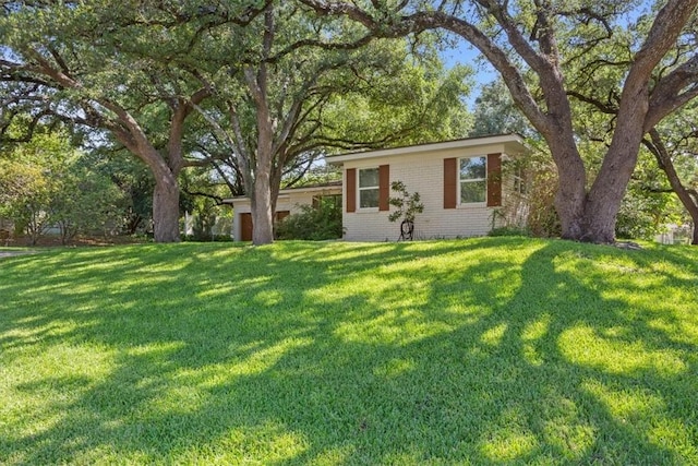 view of front facade with a front yard and brick siding