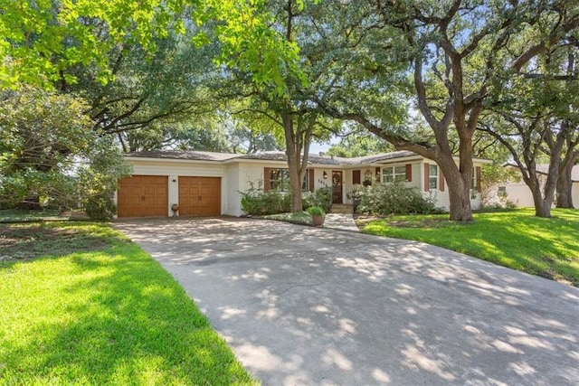 ranch-style home with a front lawn, a garage, and driveway