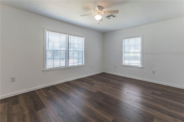 spare room with dark hardwood / wood-style floors, a healthy amount of sunlight, and ceiling fan