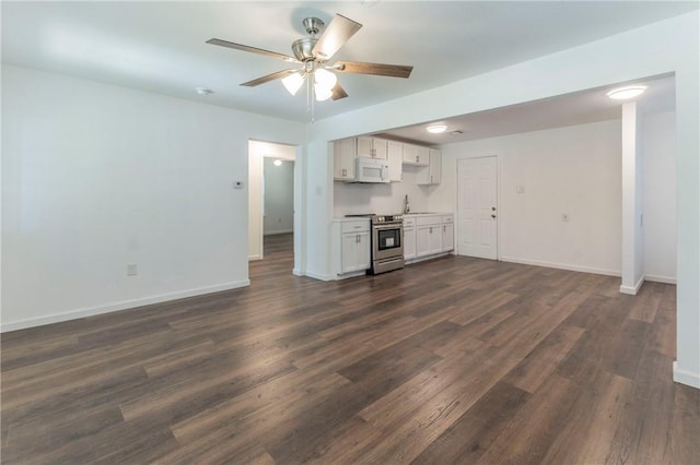 unfurnished living room with ceiling fan, sink, and dark wood-type flooring