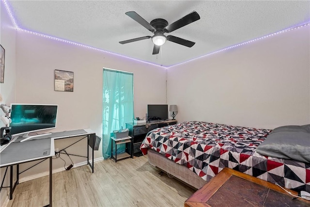 bedroom with ceiling fan, a textured ceiling, and light wood-type flooring