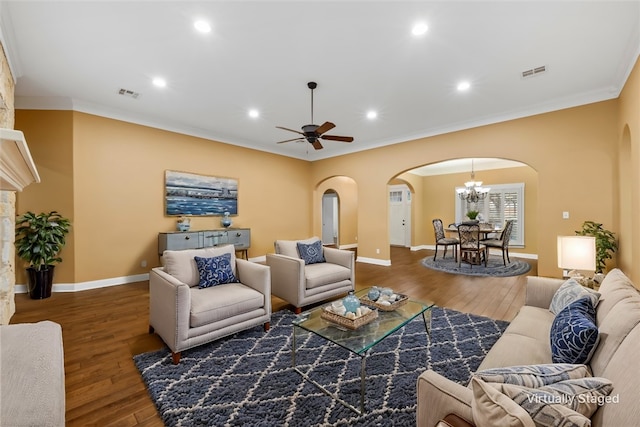 living room featuring ceiling fan with notable chandelier, dark hardwood / wood-style floors, and ornamental molding