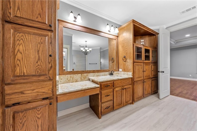 bathroom with hardwood / wood-style flooring, vanity, ornamental molding, and an inviting chandelier