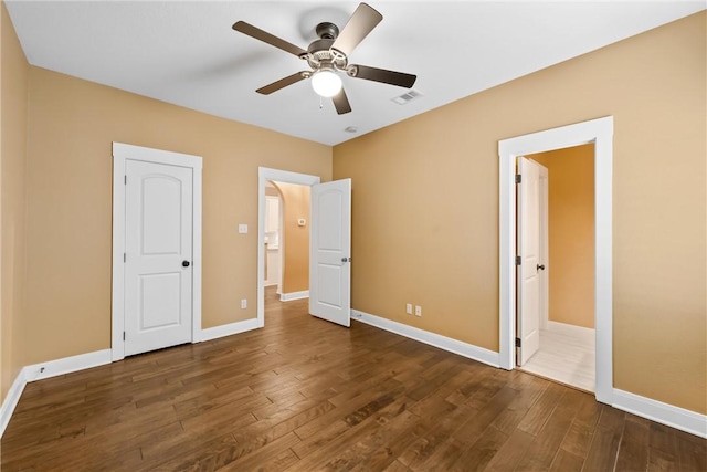 unfurnished bedroom featuring dark hardwood / wood-style flooring and ceiling fan