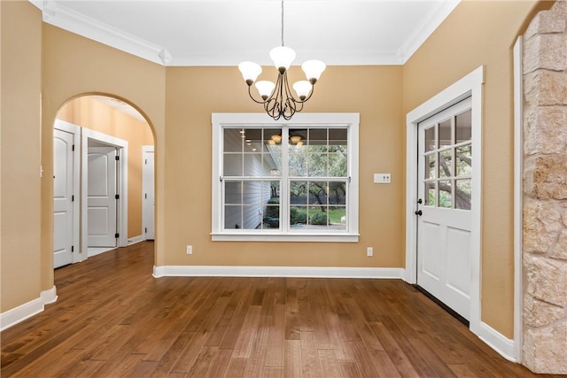 unfurnished dining area featuring a chandelier, dark hardwood / wood-style floors, and ornamental molding