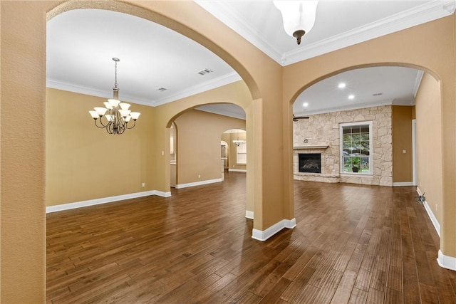 unfurnished living room featuring a fireplace, dark hardwood / wood-style flooring, a chandelier, and crown molding