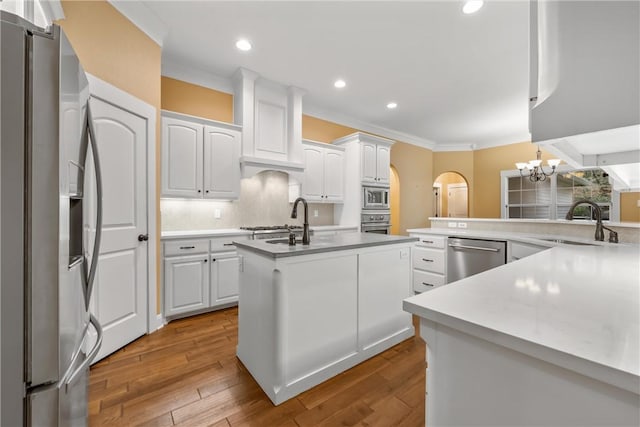 kitchen featuring white cabinetry, sink, light wood-type flooring, and appliances with stainless steel finishes