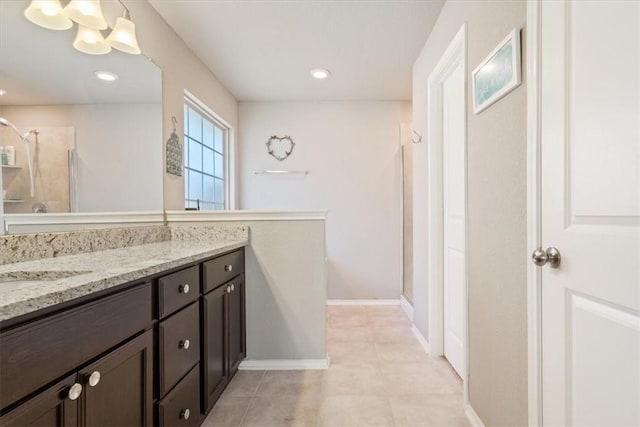 bathroom featuring recessed lighting, baseboards, a shower stall, and vanity