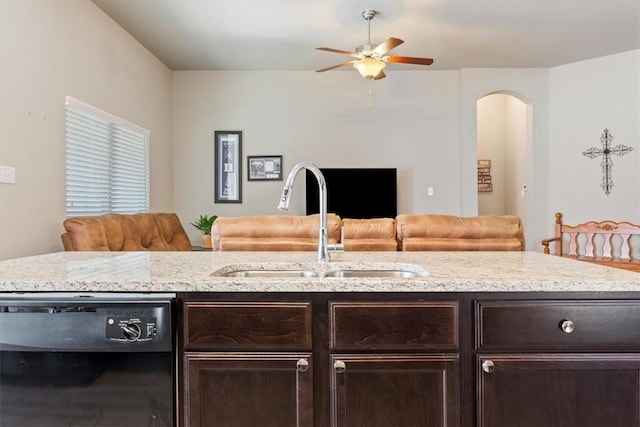 kitchen featuring black dishwasher, dark brown cabinetry, a sink, and open floor plan