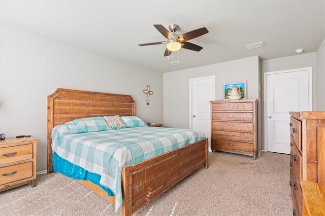 bedroom featuring visible vents, a ceiling fan, and light colored carpet