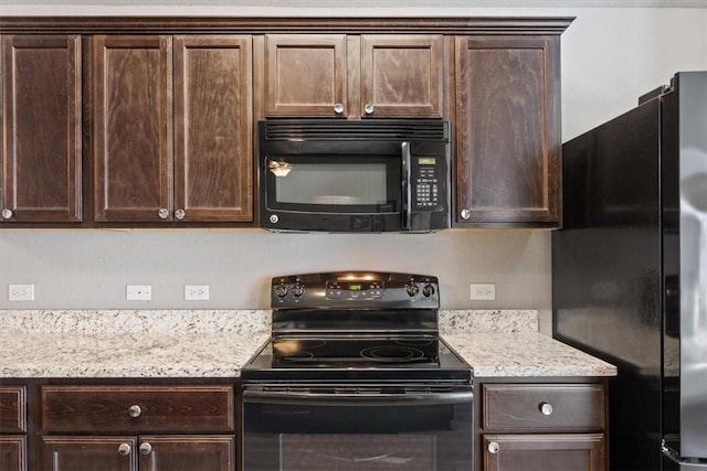 kitchen with light stone counters, dark brown cabinets, and black appliances