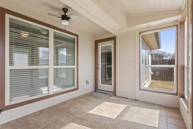 unfurnished sunroom with a ceiling fan