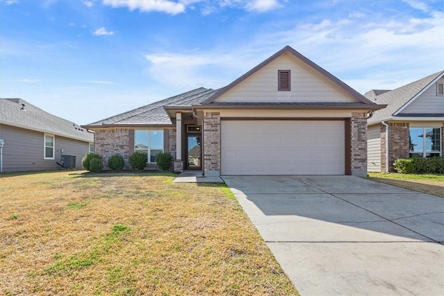 view of front of property with central air condition unit, a garage, brick siding, driveway, and a front lawn