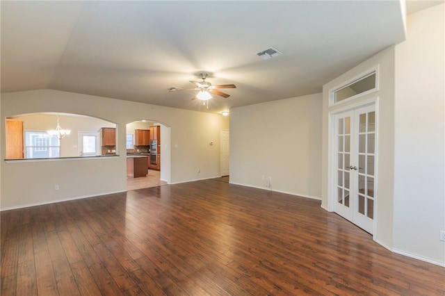 unfurnished living room with french doors, ceiling fan with notable chandelier, dark hardwood / wood-style flooring, and lofted ceiling